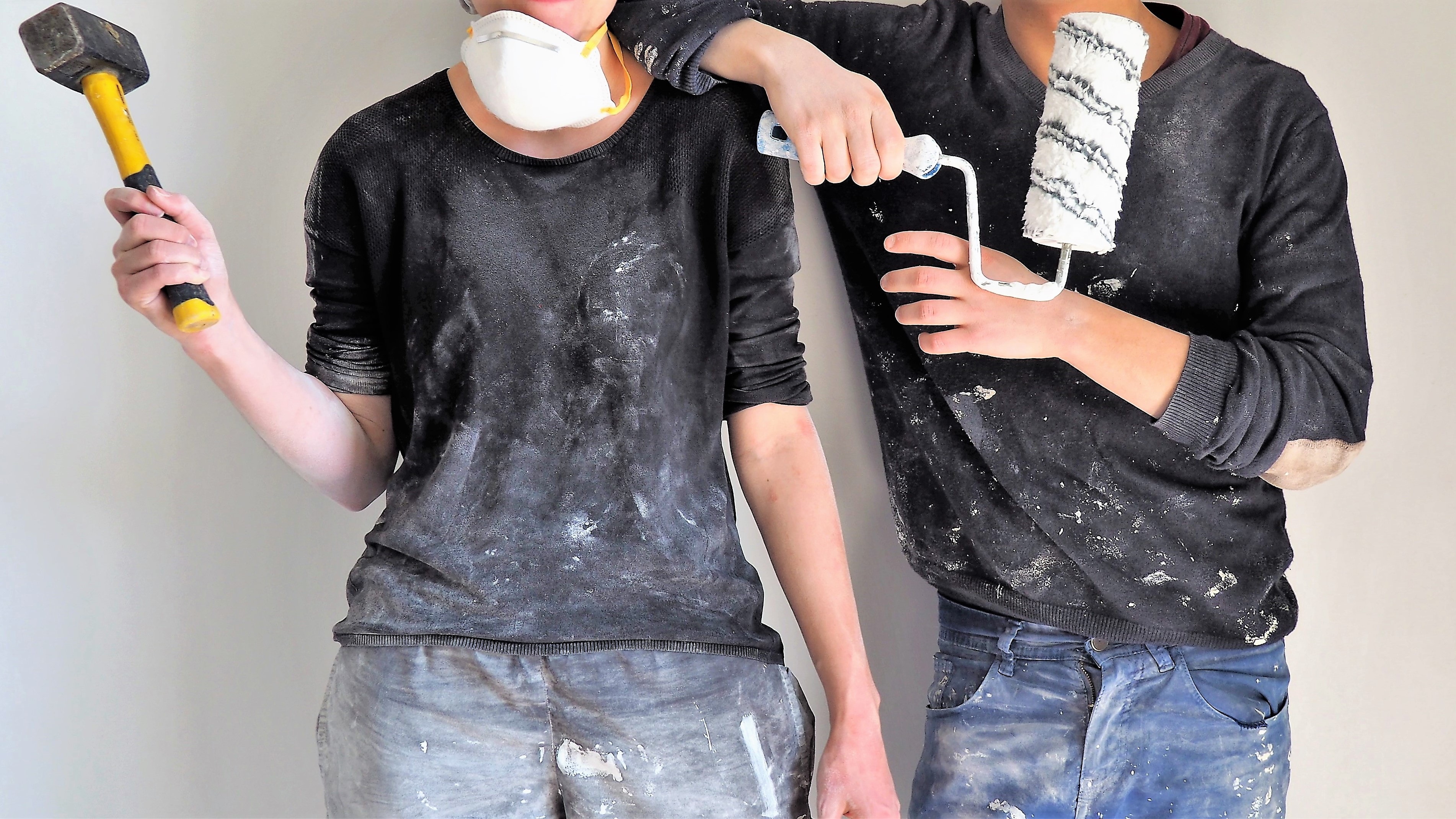 Couple In Paint Covered Clothes With Paint Rollers