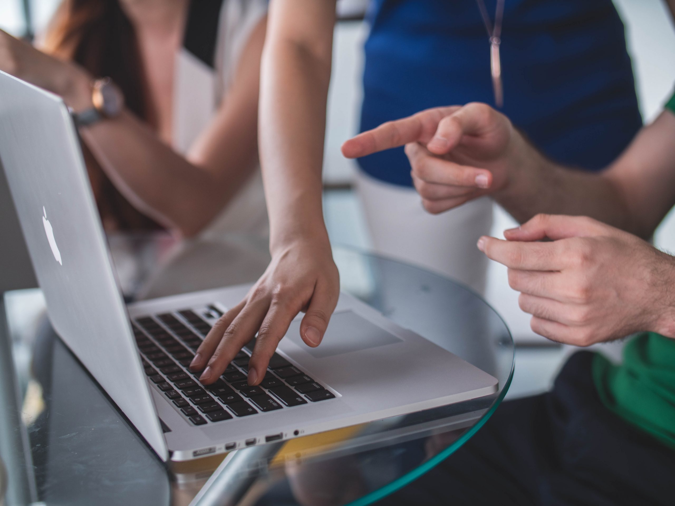 Three People On A Laptop With One Pointing To Screen