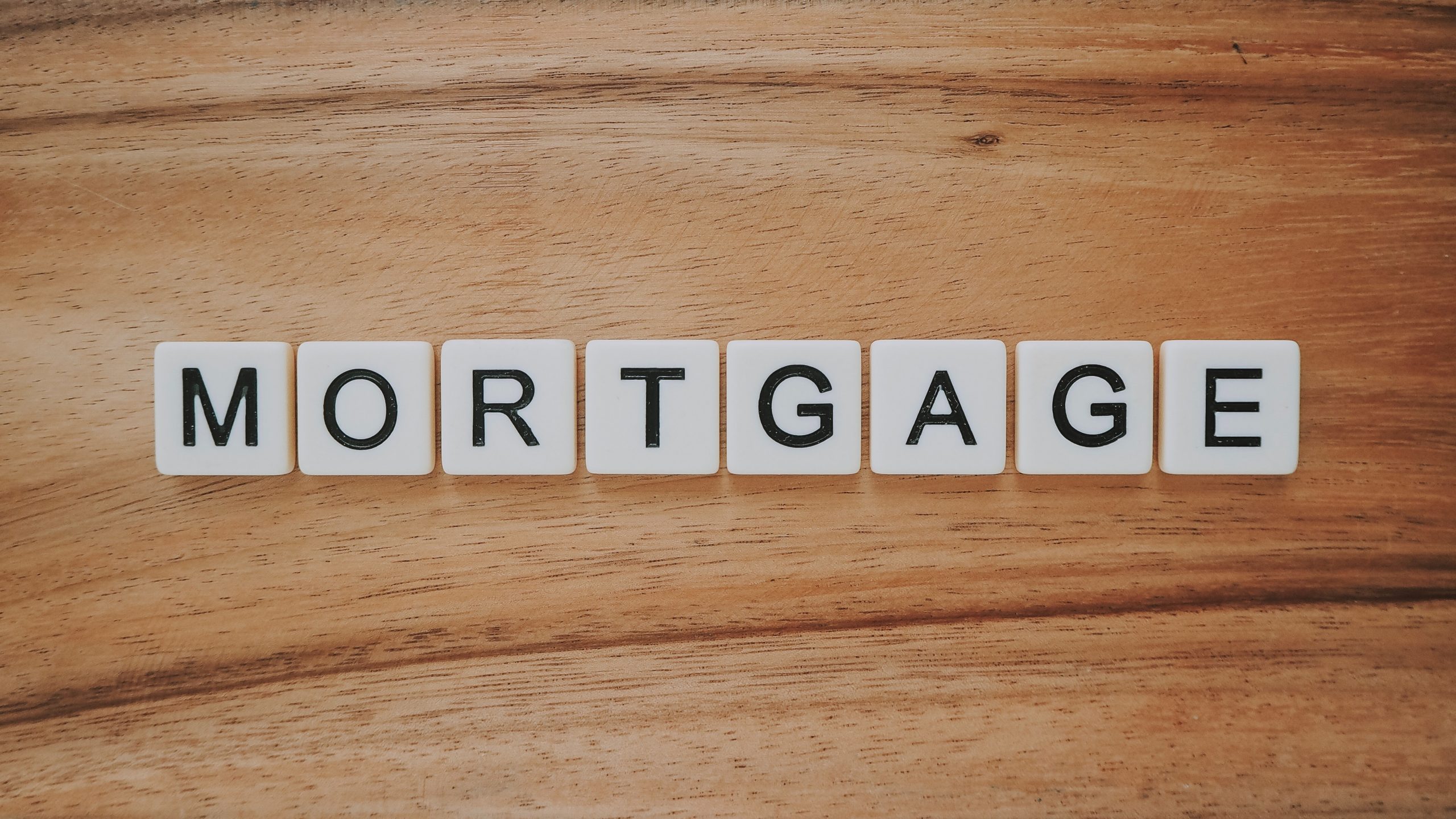 Mortgage Spelled Out In Tiles On A Wood Background